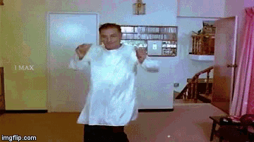a man in a white shirt is dancing in a room with imax written on the wall
