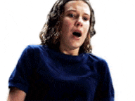 the woman is wearing a blue shirt and making a surprised face .