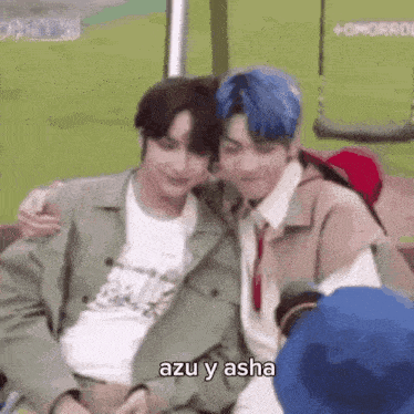 two men are sitting next to each other on a bench and hugging .