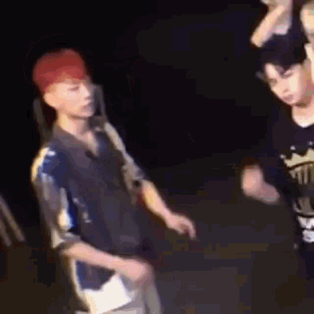 a group of young men are standing next to each other in the dark .