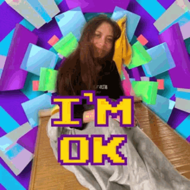 a woman is laying on a bed with a blanket and the words `` i 'm ok '' written on it .