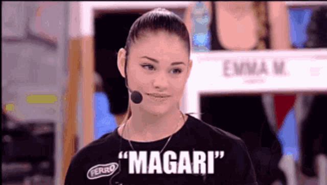 a woman wearing a microphone and a black shirt that says " magari "