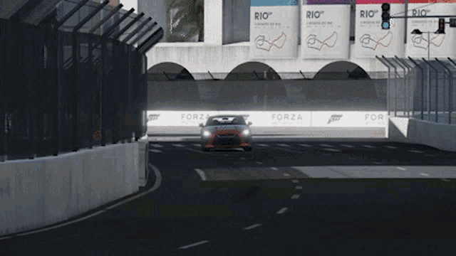 a car is driving down a race track with signs that say forza