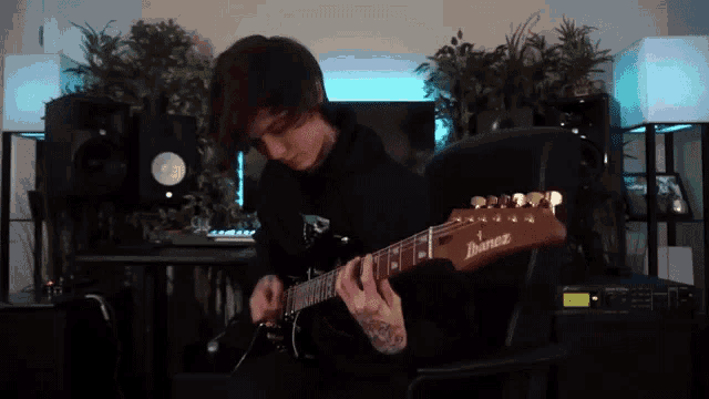 a man is playing an ibanez electric guitar