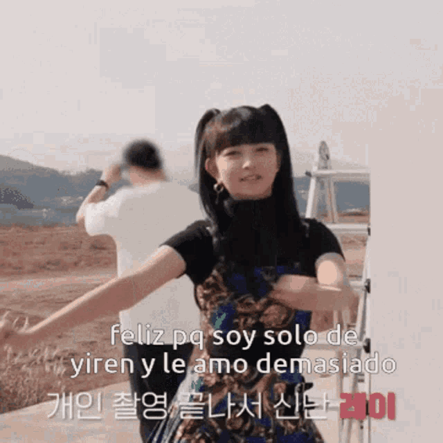 a girl with pigtails is standing in front of a sign that says feliz pq soy solo de