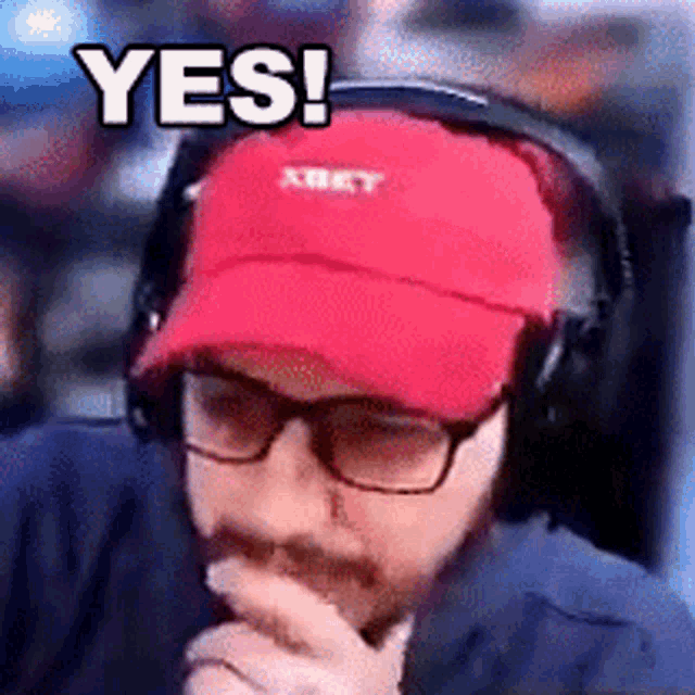 a man wearing headphones and a red hat with the word yes written on it