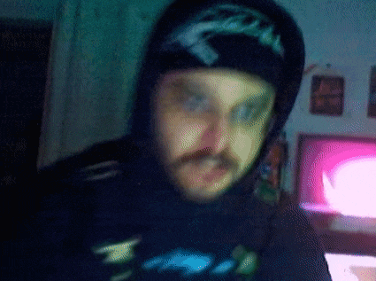 a blurry picture of a man wearing a hoodie and a hat with the word eagle on it