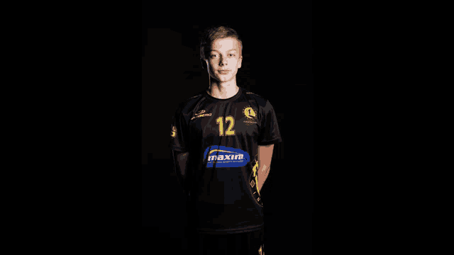 a boy in a black shirt with the number 12 on it