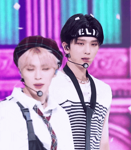 a man wearing a headband that says eli is standing next to another man