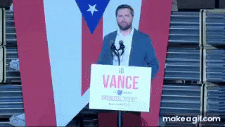 a man is standing in front of a microphone holding a sign that says vance