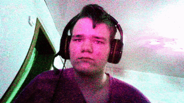 a man with a mohawk wearing headphones looks at the camera
