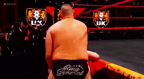a man is standing in a wrestling ring wearing a pair of ring general trunks .