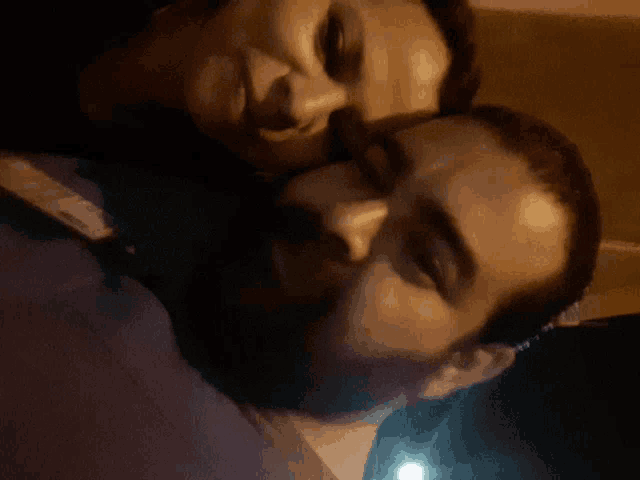 a man with a beard kisses another man on the cheek