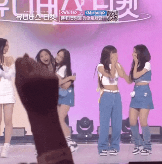 a group of girls standing on a stage with a sign above them that says white vs miracle
