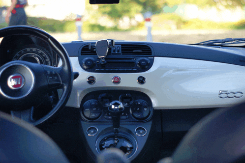 the inside of a white fiat 500 car with a steering wheel