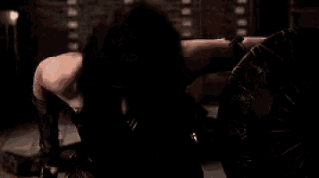 a woman in a wonder woman costume is kneeling down on the floor .