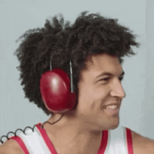 a man wearing red headphones is smiling and looking at the camera .
