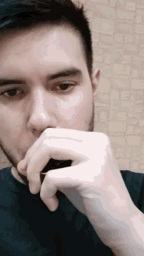 a man with a beard holds his hand to his mouth