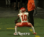a football player in a red and white uniform is kneeling on the field .