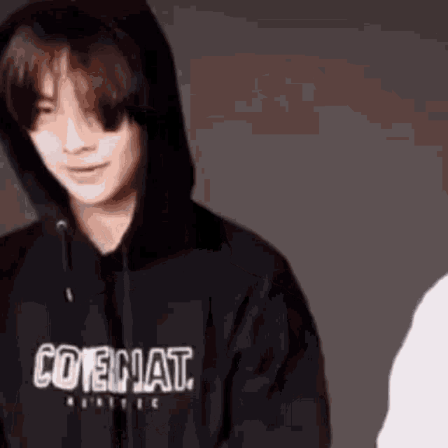 a young man wearing a black hoodie is looking at the camera .