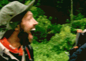 a pixelated image of a man wearing a hat and scarf in the woods