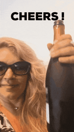 a woman wearing sunglasses is holding a bottle of wine with the word cheers written above her