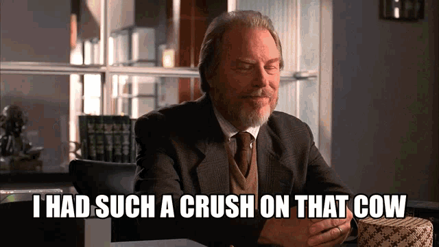 a man in a suit and tie is sitting at a table and says i had such a crush on that cow