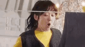 a woman is standing in front of a clothes line with her mouth open .