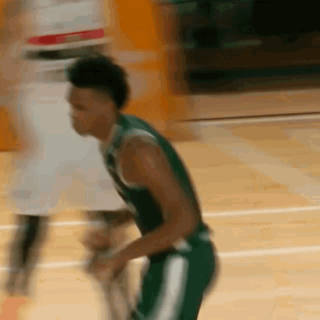 a blurry picture of a basketball player in a green jersey