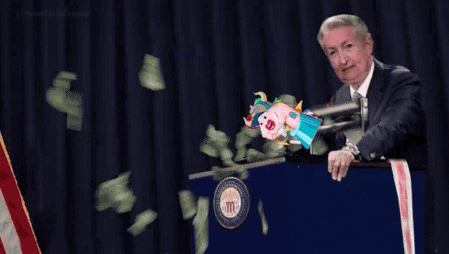 a man stands at a podium with money falling around him and a ribbon that says montana
