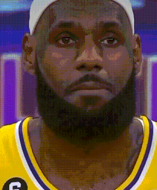a close up of a basketball player with a beard wearing a hat and a yellow jersey .