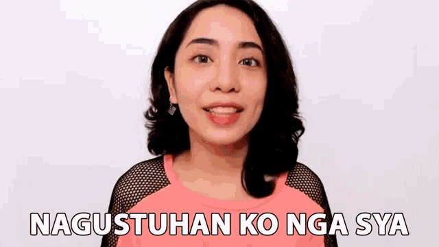 a woman in a pink shirt is smiling with the words nagustuhan ko nga sya below her .