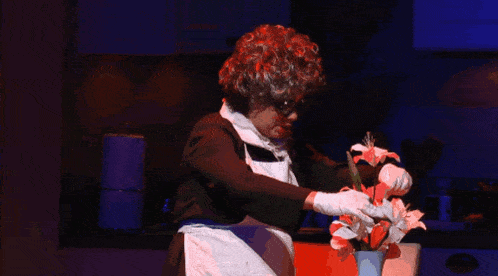 a woman in an apron and white gloves holds flowers