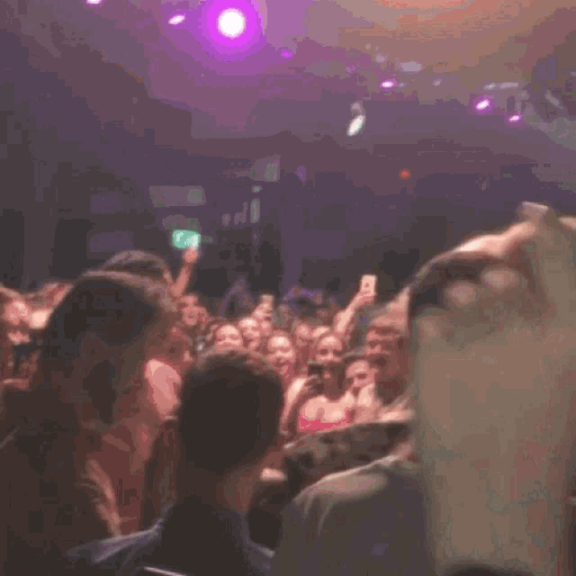 a group of people are dancing in a dark room