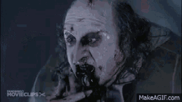 a skeleton is walking through a dark room in a movie scene .