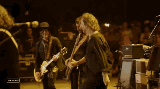 a man playing a guitar in front of a crowd with the words stagecoach on the bottom