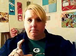a woman wearing a green bay packers shirt makes a funny face