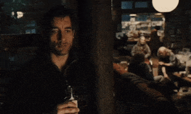 a man is holding a bottle of whiskey in his hand