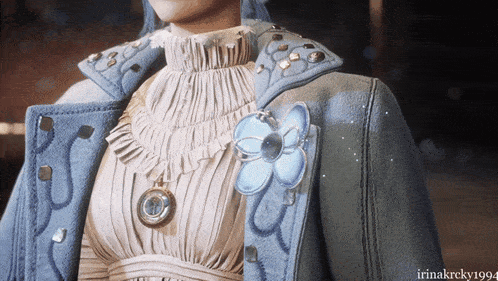 a close up of a woman wearing a blue jacket with a blue flower on it