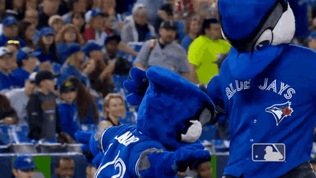 a mascot for the blue jays is giving a high five