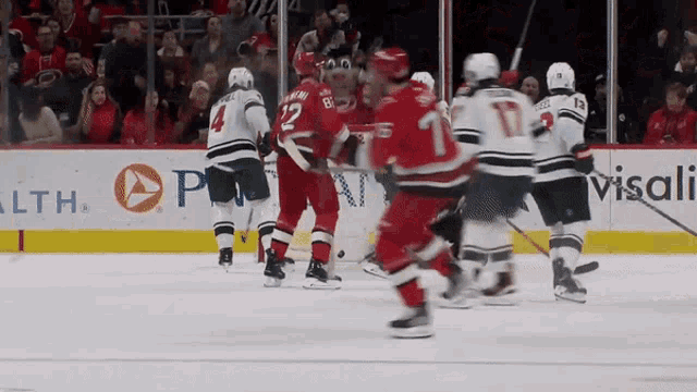 a hockey game is being played in front of a visali advertisement