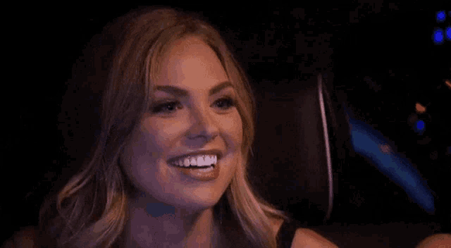 a woman is smiling while sitting in the back seat of a car at night .