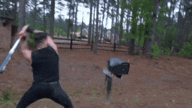 a man is swinging a bat at a mailbox in a forest