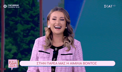 a woman in a pink jacket is laughing on a tv show called the break