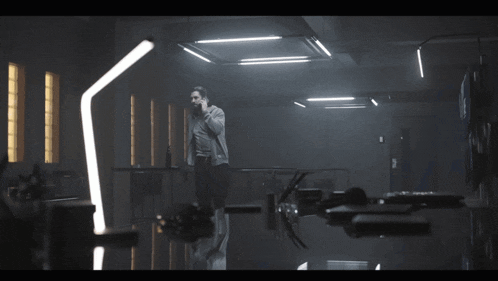 a man standing in a dark room with a reflection of him in the floor