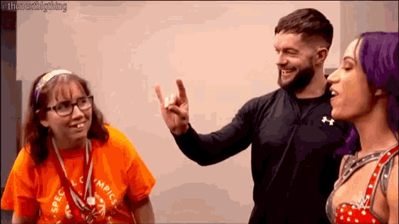 a man with a beard is giving a high five to a woman with glasses and purple hair .