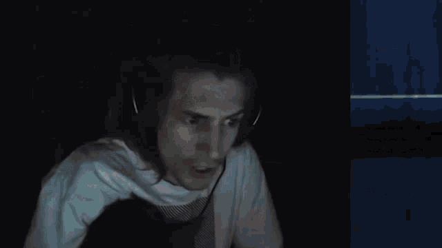 a man wearing headphones is smiling in front of a screen that says twitch