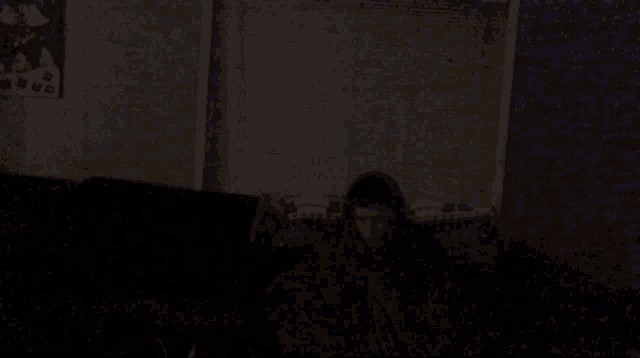 a person is sitting on a couch in a dark room