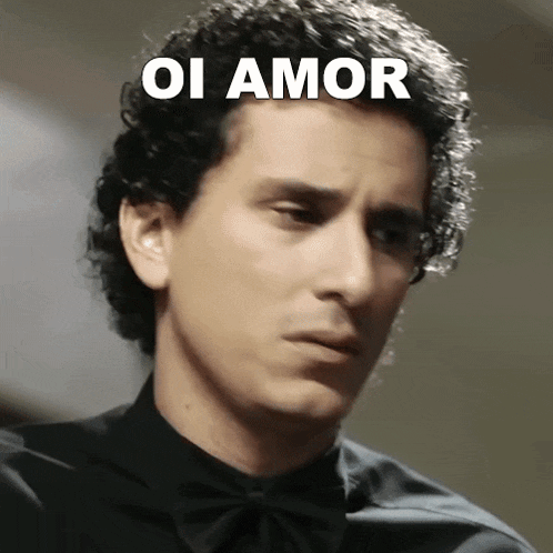 a man in a black shirt and bow tie with the words oi amor written on his face