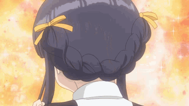 a close up of a girl 's hair with two yellow ribbons in it